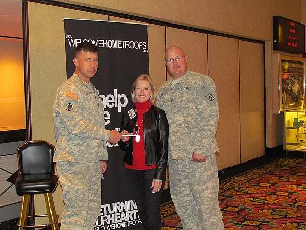 Welcome Home Troops photo with two soldiers posing with Sue Rebar